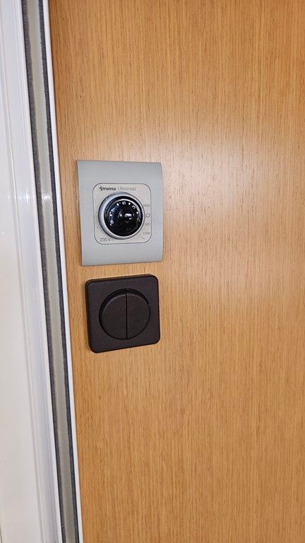 Un gros plan d'un interrupteur sur une porte en bois.