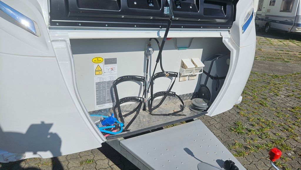 Une remorque avec la porte ouverte et un vélo à l'arrière.