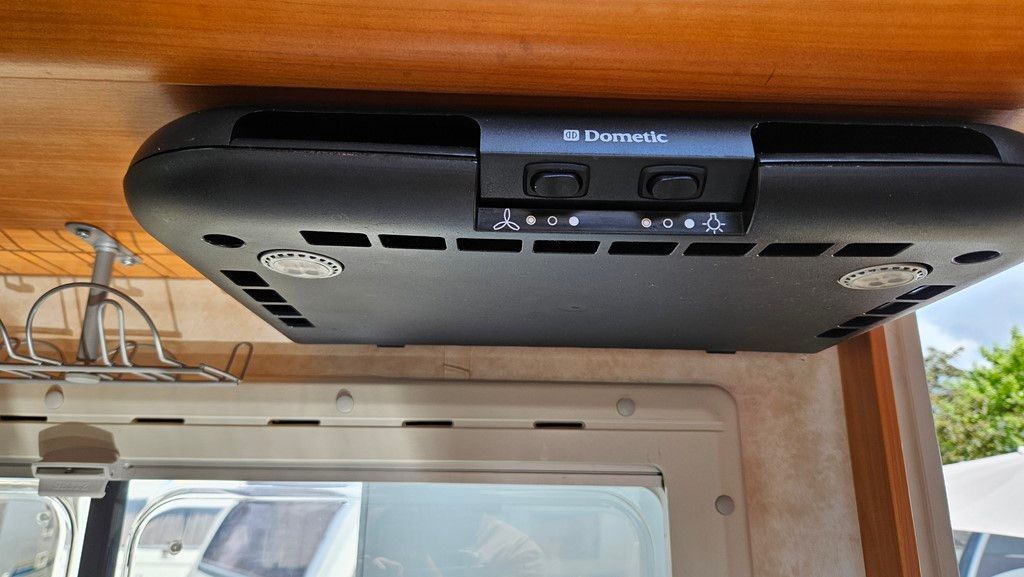 Un ventilateur de plafond est suspendu au plafond d'un camping-car.