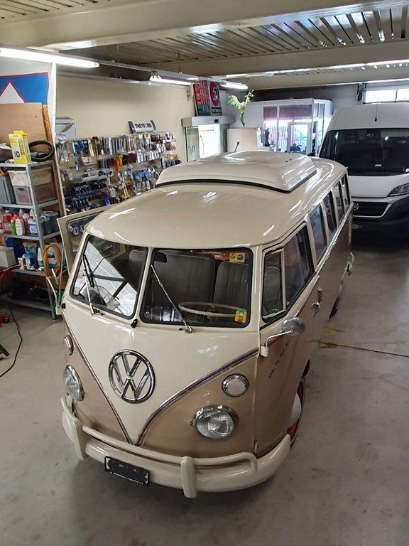 Une camionnette marron et blanche est garée dans un garage.