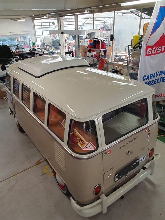 Une camionnette blanche est garée dans un garage à côté d'un drapeau.