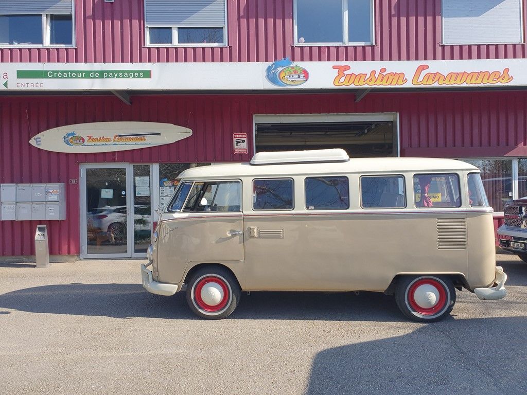 Une camionnette blanche est garée devant un bâtiment rose