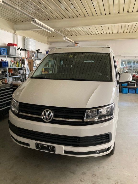 Une camionnette Volkswagen blanche est garée dans un garage.