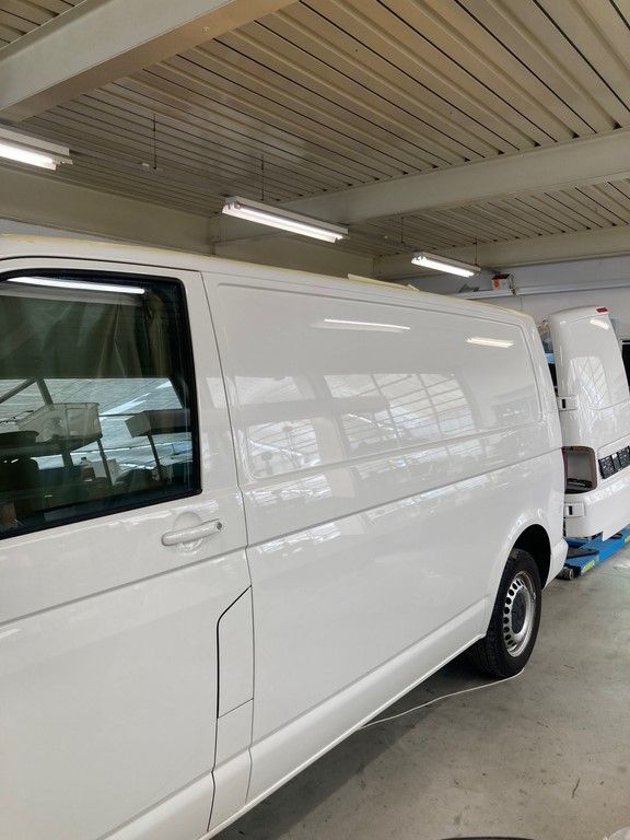 Une camionnette blanche est garée dans un garage.