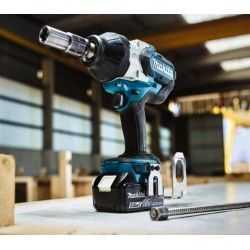 Una chiave a impulsi a batteria Makita è appoggiata su un tavolo di legno.