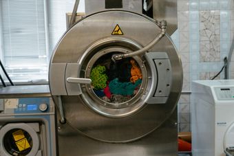 Esterilizador de laboratorio de carga frontal con objetos coloridos visibles a través de la puerta redonda.
