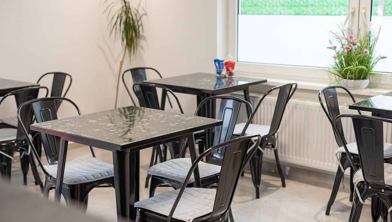 ein Esszimmer mit Tischen und Stühlen und einem Fenster .