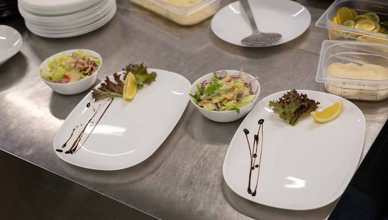 Es gibt viele Teller und Schüsseln mit Essen auf dem Tisch .