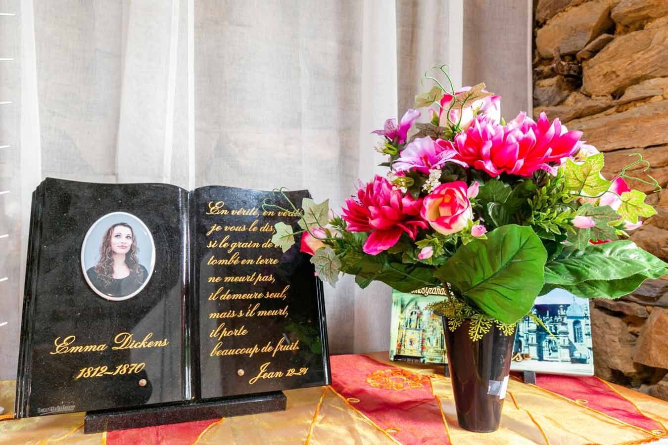 Plaque funéraire et fleurs artificielles à côté