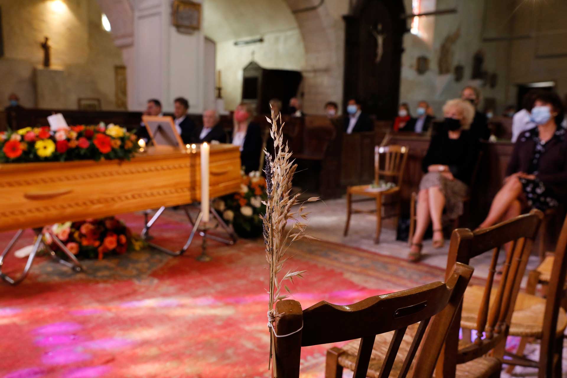 Cérémonie dans une église avec un cercueil au centre
