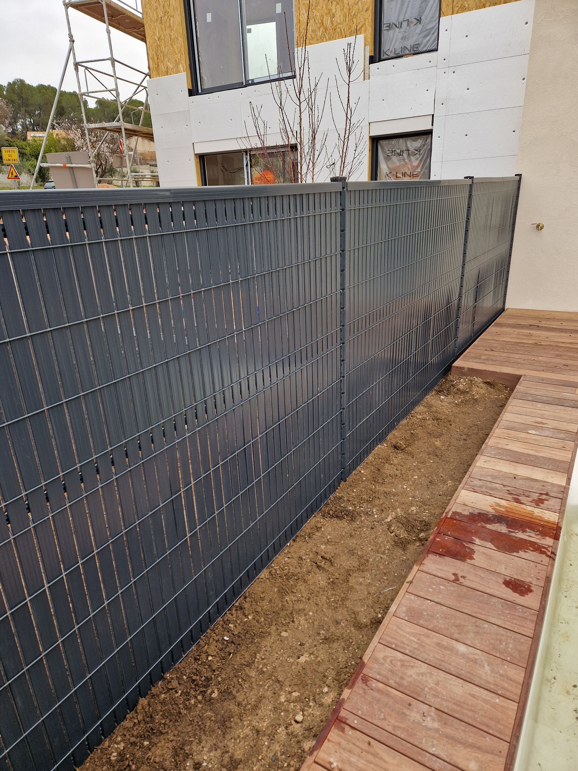 Claustra en PVC noir devant une terrasse en bois