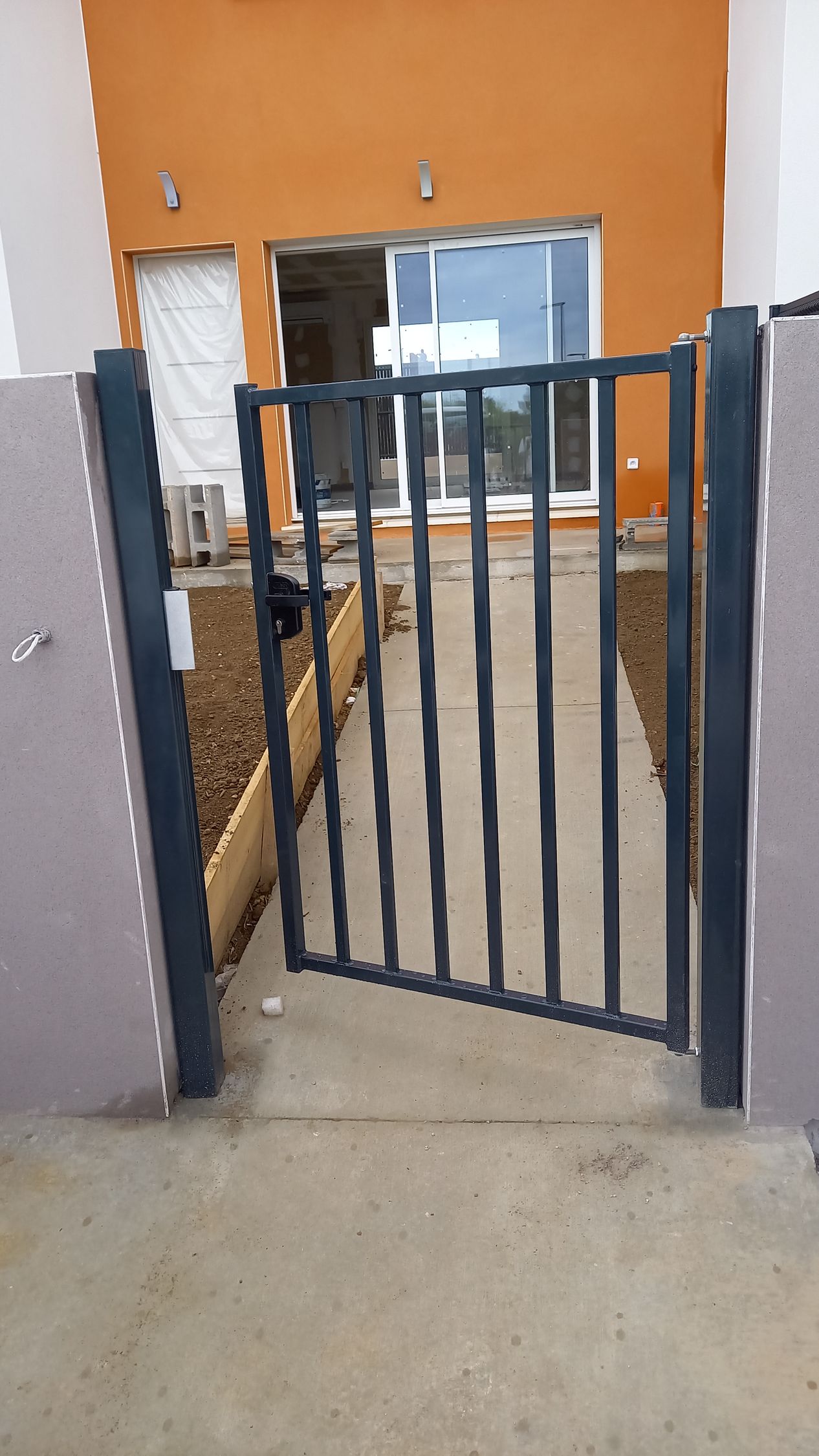 Portillon installé avec chemin menant à une porte vitrée