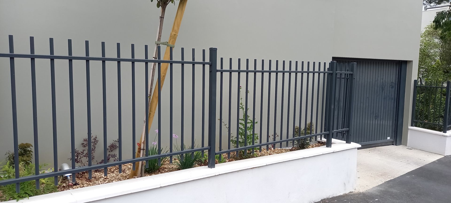 Clôture en fer sur un muret blanc