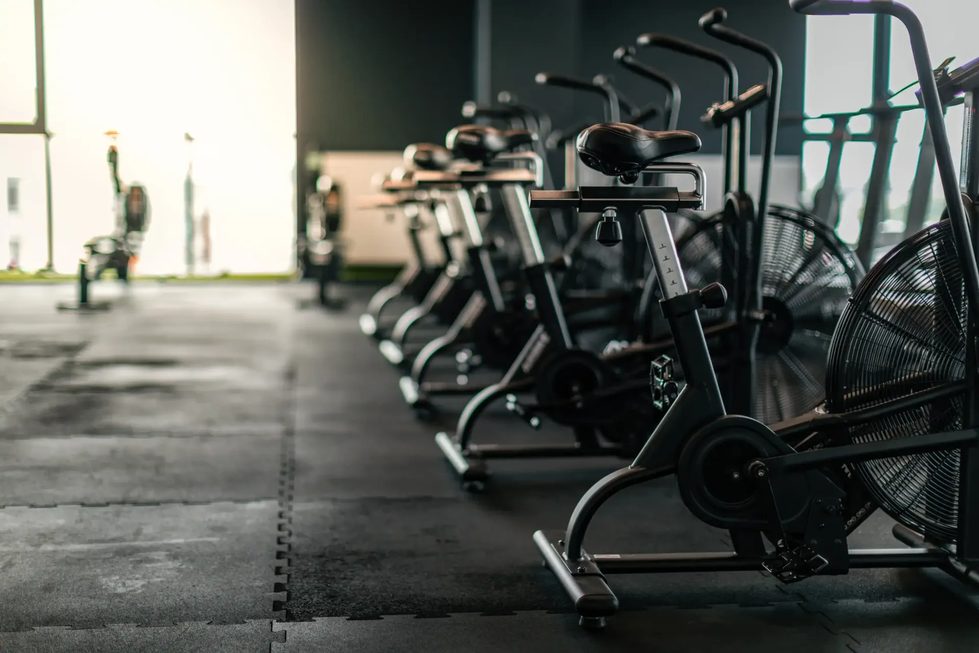 Una fila de bicicletas estáticas están alineadas en un gimnasio.