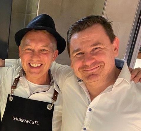 Zwei Köche die in der Küche stehen und ein Selfi-machen