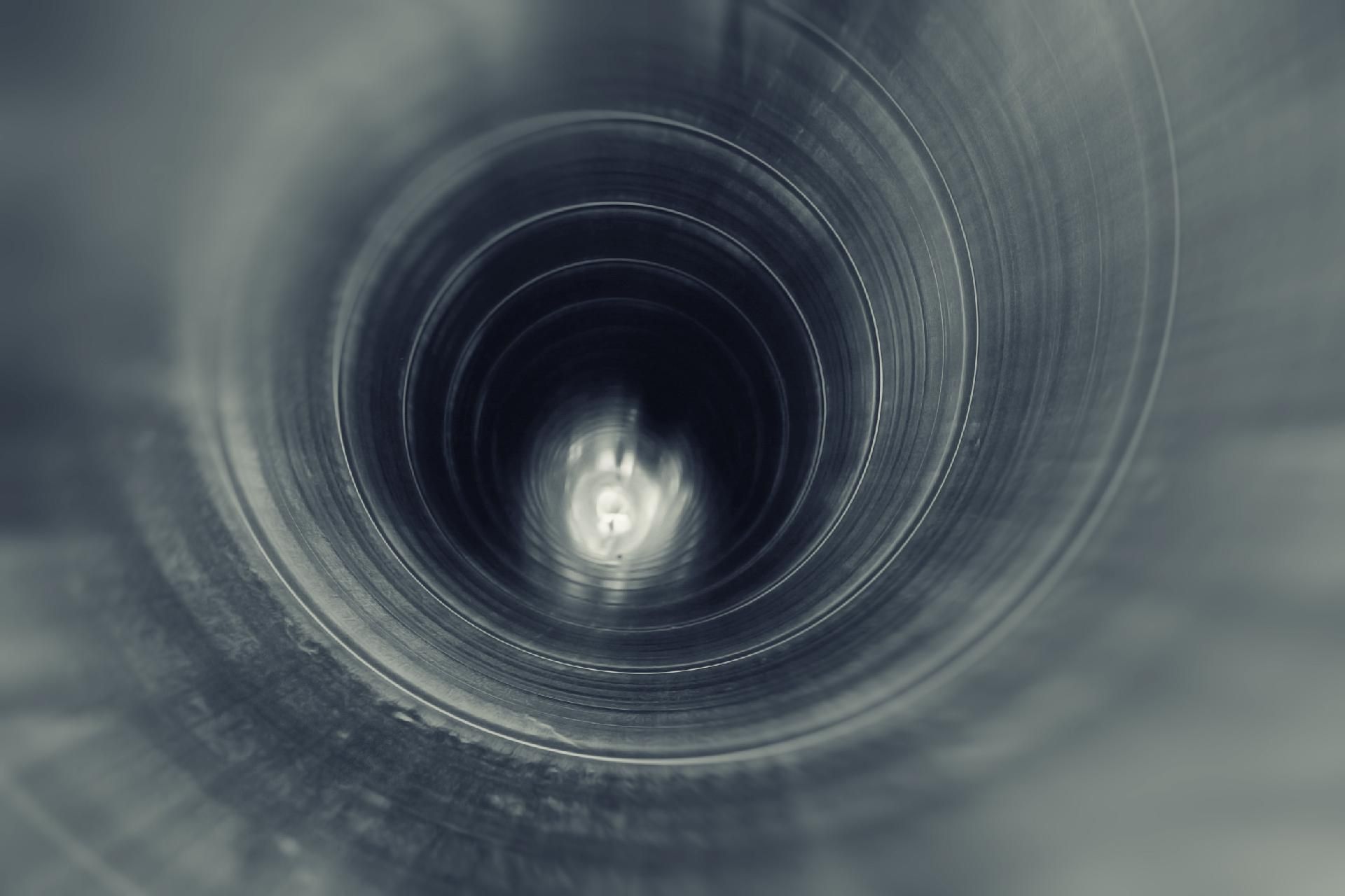Ein sauberes Rohr Abstrakte Ansicht eines grauen Metalltunnels mit einem hellen Licht in der Mitte