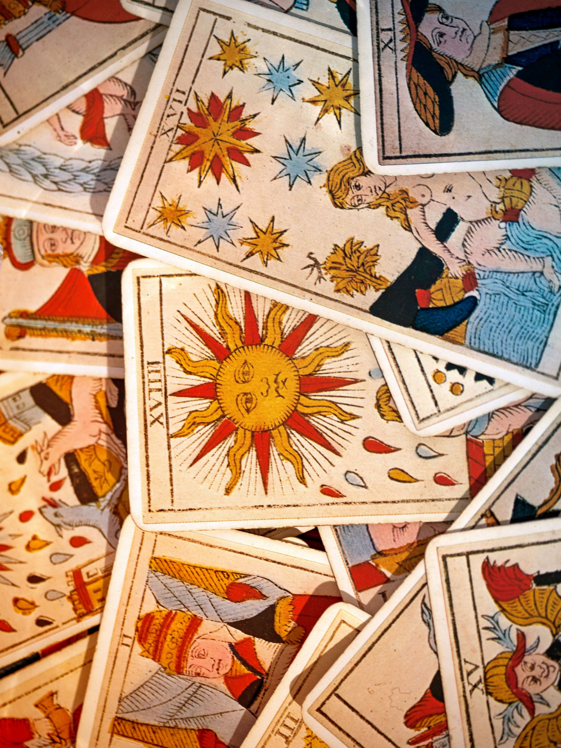 Cartes de tarot dispersées, représentant le soleil, les étoiles et les personnages.