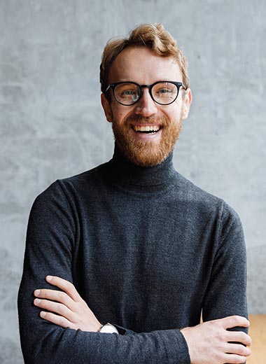 Homme avec une barbe et des lunettes qui sourit