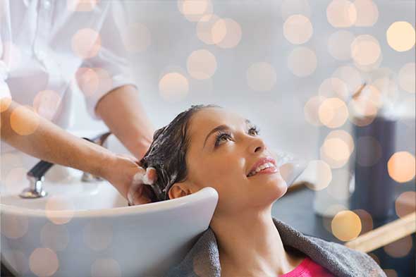 Une femme profite d'un shampooing chez le coiffeur