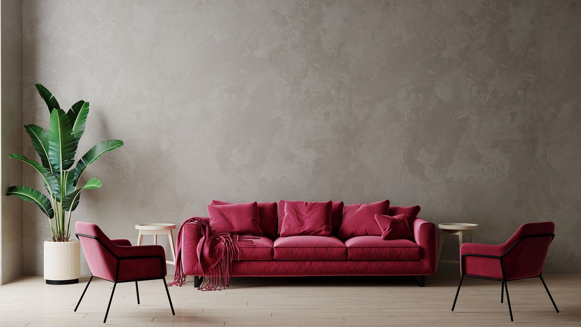 Un salon avec un canapé rouge et  le mur du fond en enduit décoratif