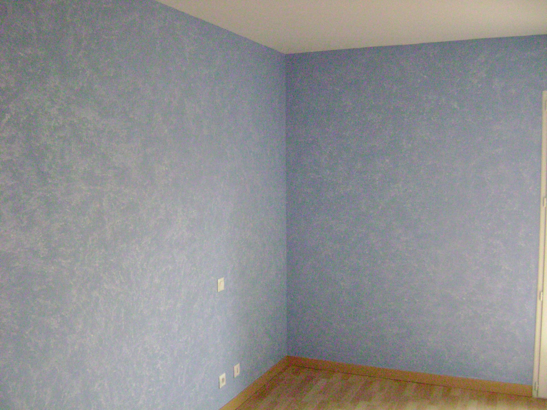 Un mur de salon avec du papier peint bleu