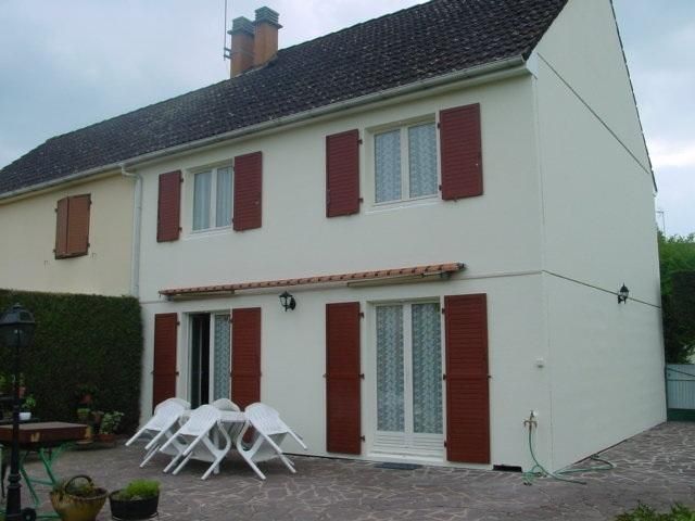 Une façade de maison avec des volets rouges