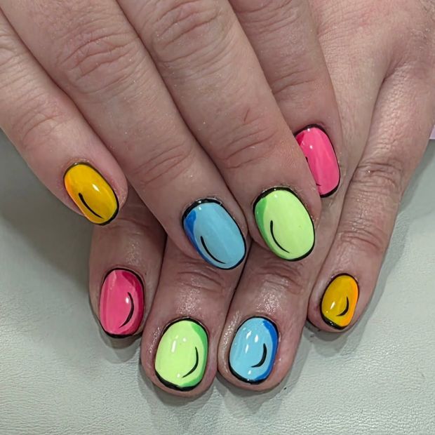 Manos que muestran esmalte de uñas ovalado de colores rosa, amarillo, azul y verde.
