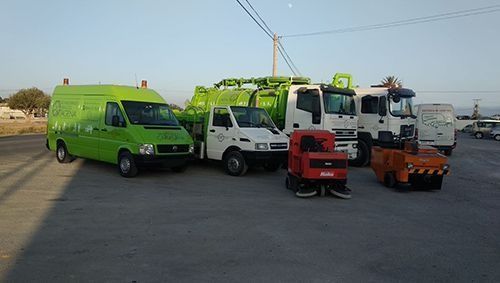 Una fila de camiones verdes y blancos están estacionados en un estacionamiento.