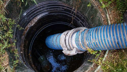 Una manguera azul sale de un tanque séptico.