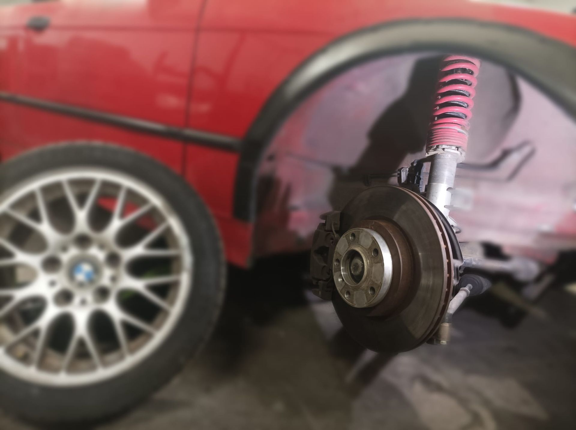 Un coche rojo con un amortiguador rosa.