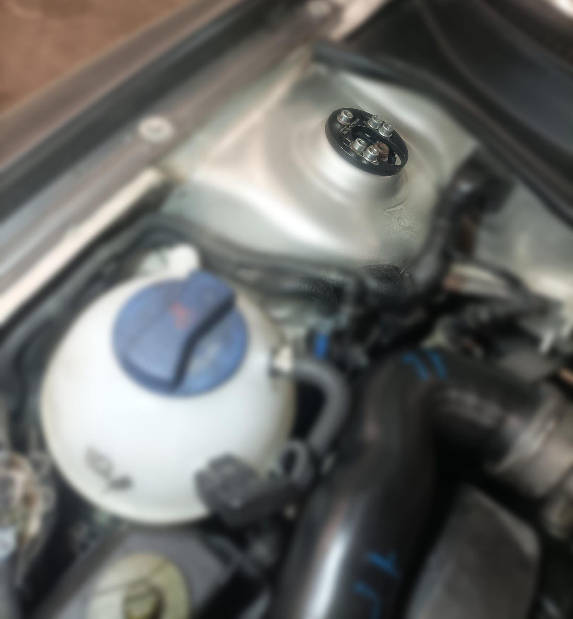 Un primer plano de un motor de automóvil con una tapa azul.