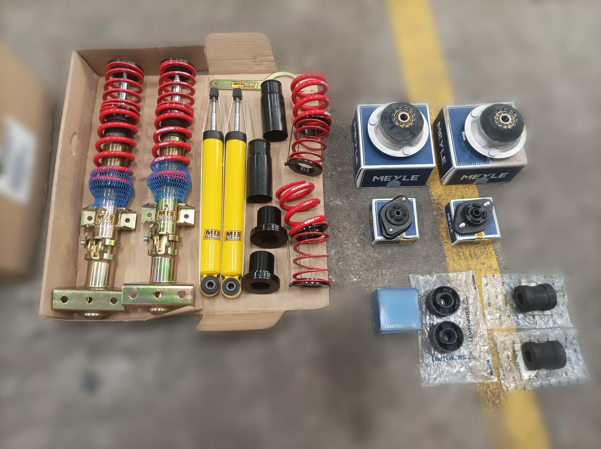 Una caja llena de amortiguadores, resortes y otras piezas.