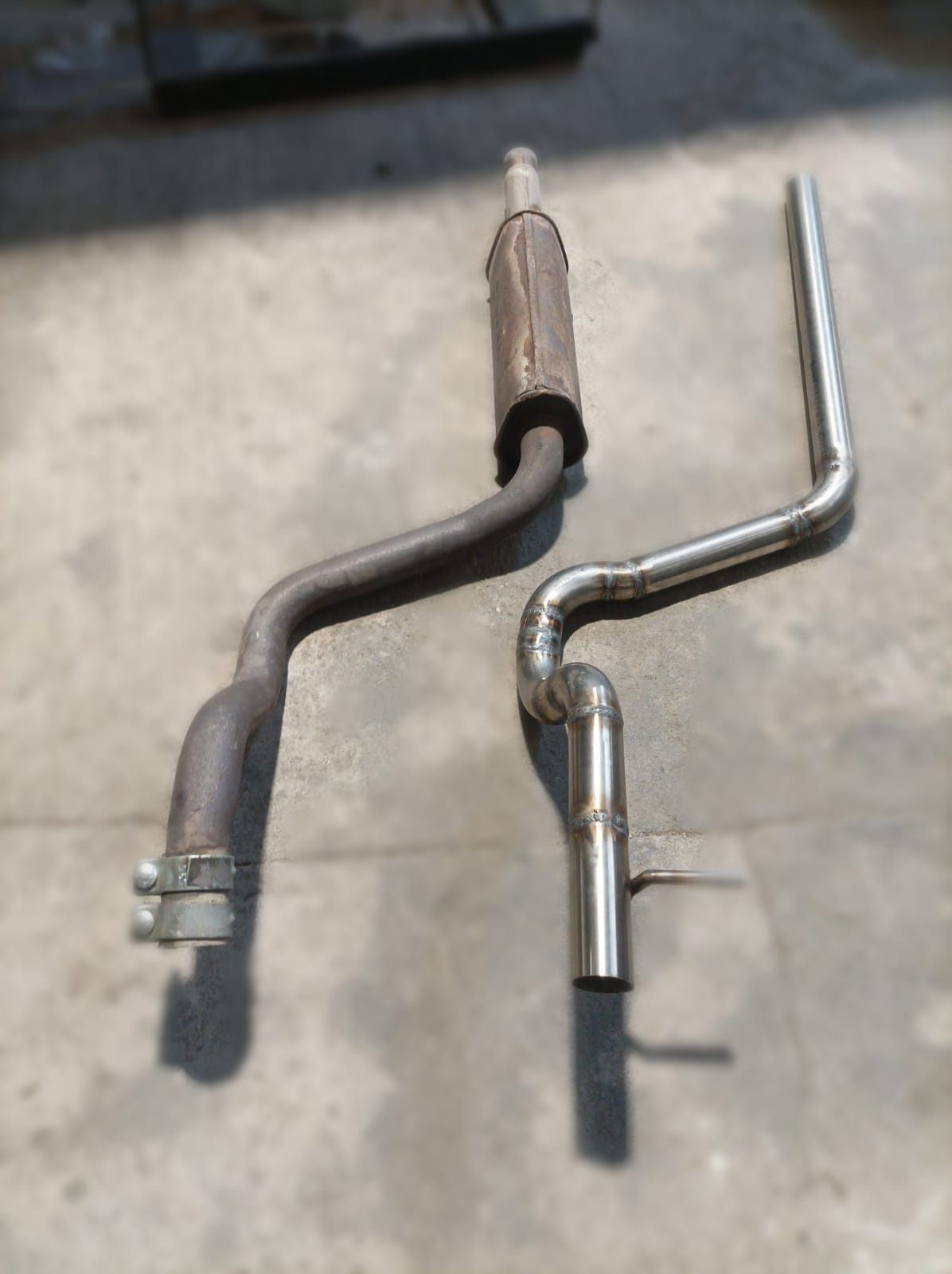 Dos tubos de escape están colocados uno al lado del otro en el suelo.