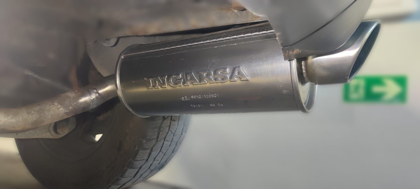 Un primer plano de un tubo de escape de un automóvil del que sale humo.