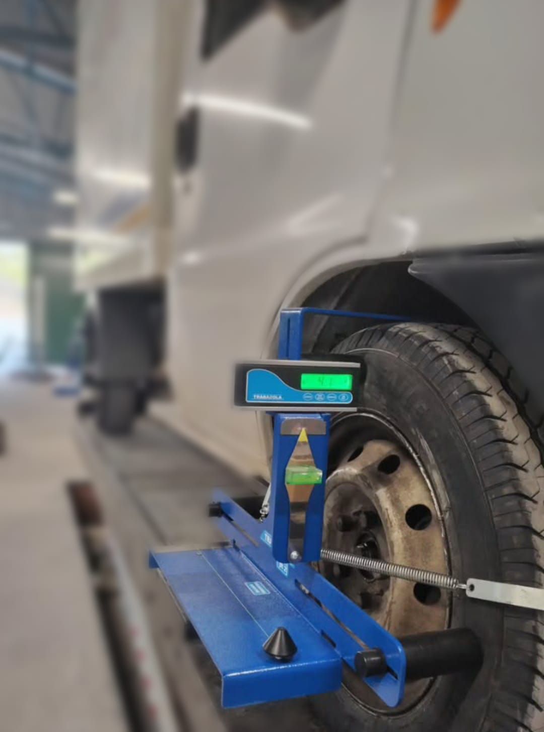 Un camión se está alineando con una máquina en un garaje.