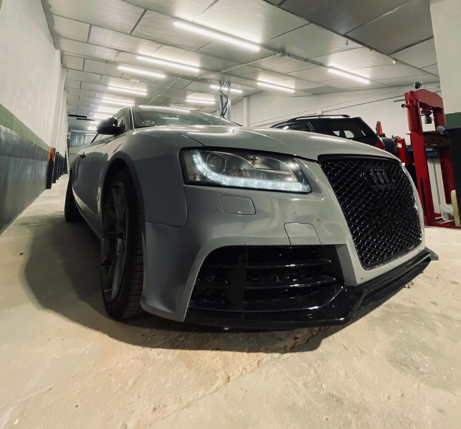 Una computadora portátil está sobre un escritorio con un montón de cables conectados a ella.