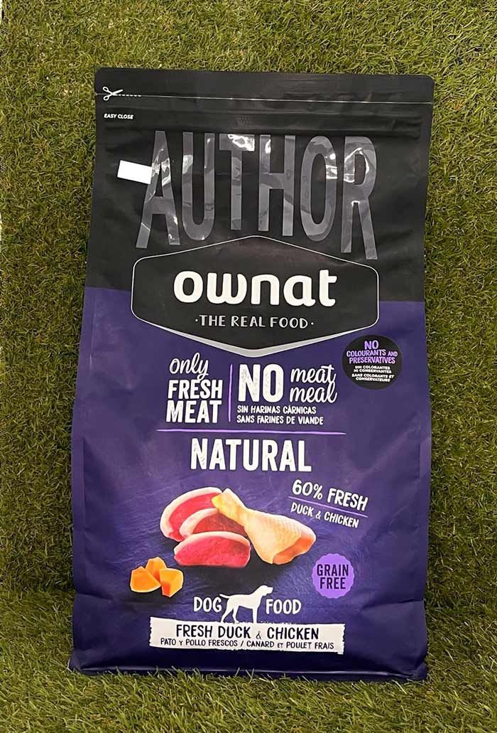 Bolsa de comida para perros Authority Ownat Naturals, envase negro y morado con gráfico de carne y logotipo blanco.
