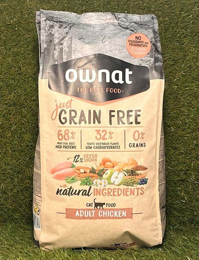 Bolsa de alimento para perros adultos Ownat sin cereales, de pollo, en envase color beige con etiquetas negras y naranjas.