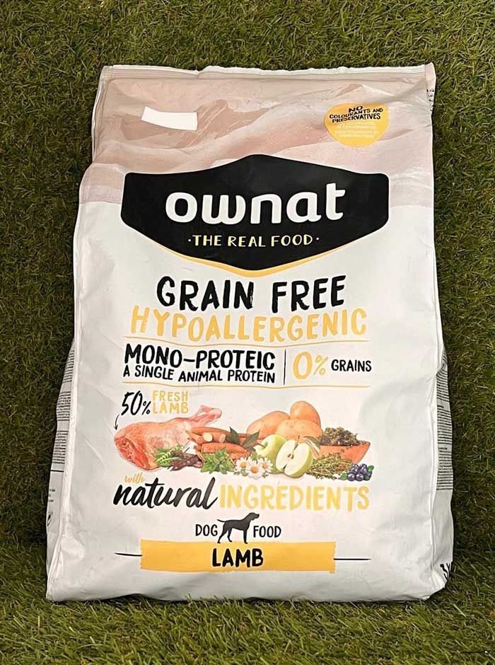 Bolsa de comida hipoalergénica sin cereales para perros Ownat con forma de cordero sobre fondo de hierba.