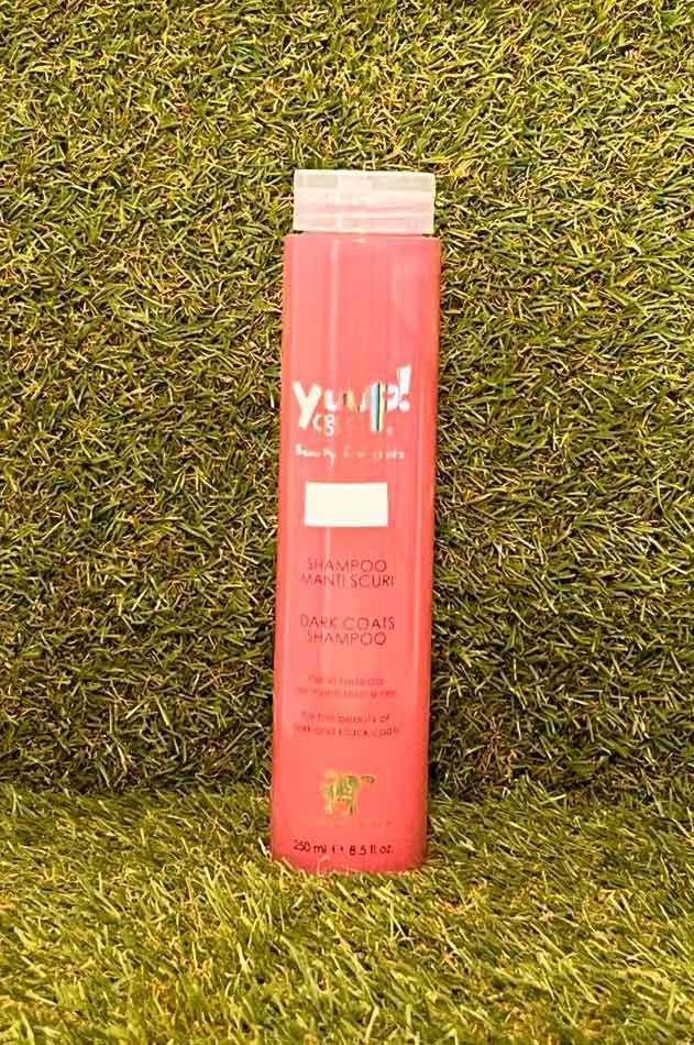 Botella cilíndrica rosa sobre césped verde.