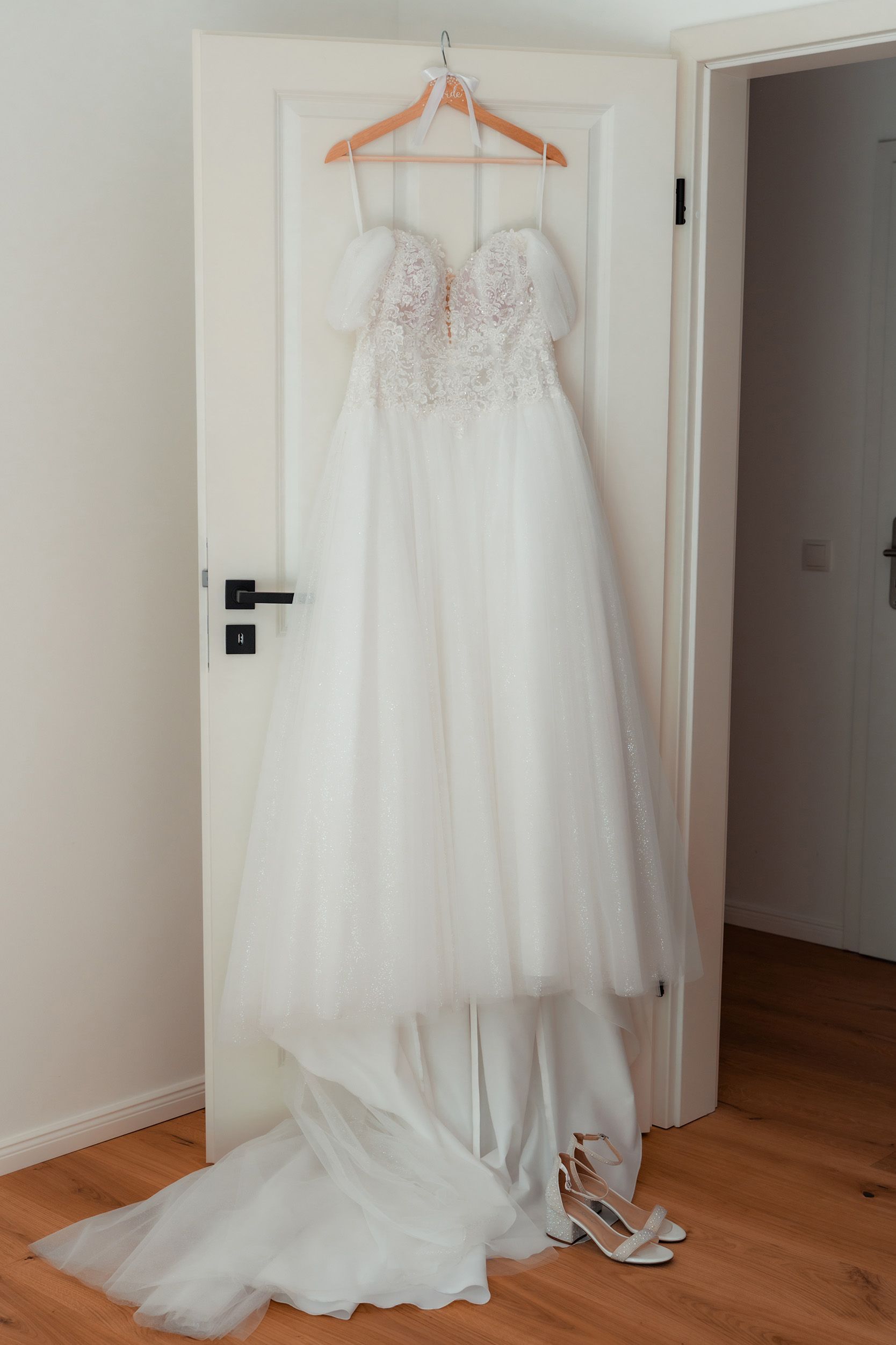 Weißes Brautkleid hängt an der Tür beim Getting Ready vor der kirchlichen Hochzeit in Bremen