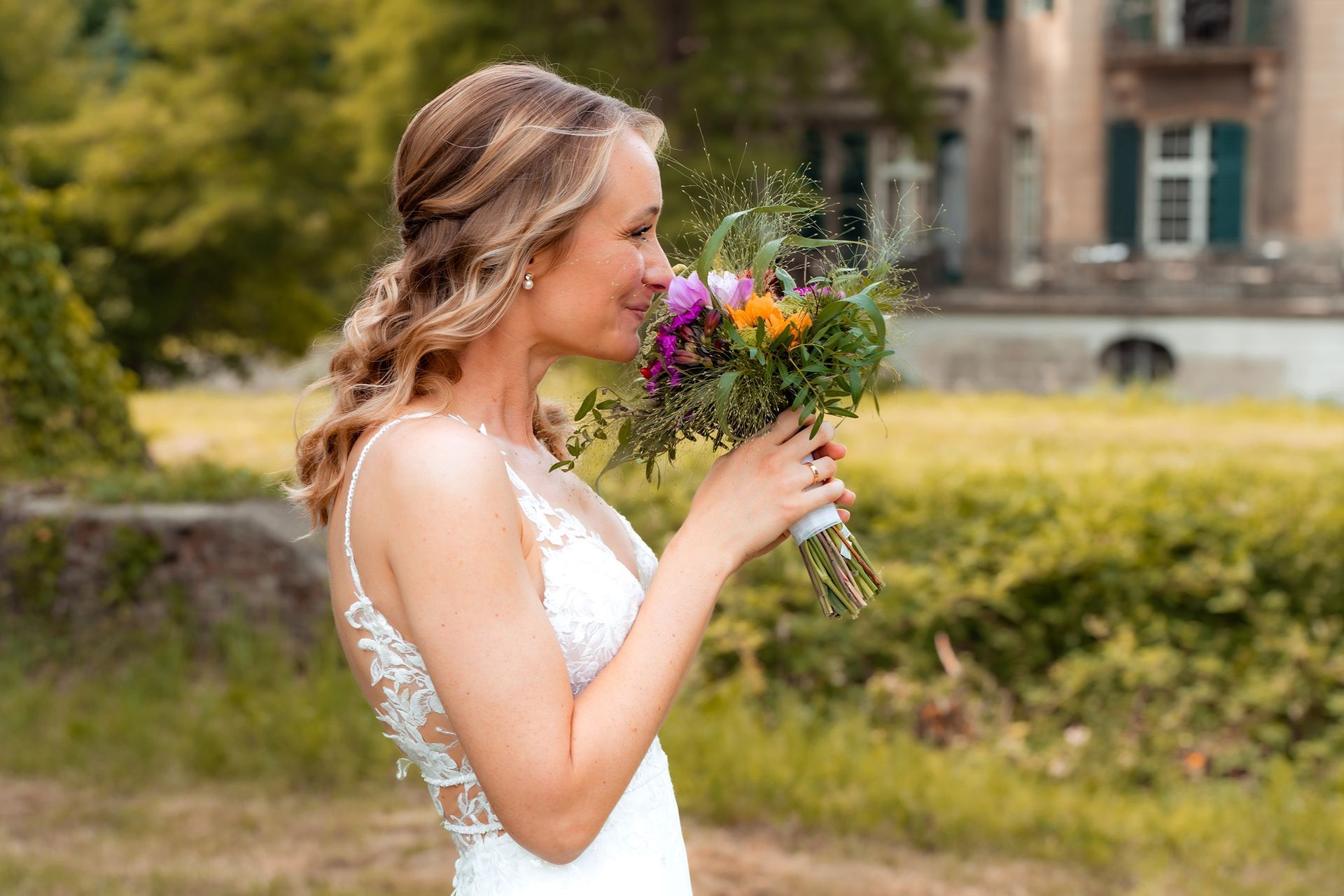 Braut mit Blumenstrauß beim Fotoshooting am Wasserschloss Solingen.