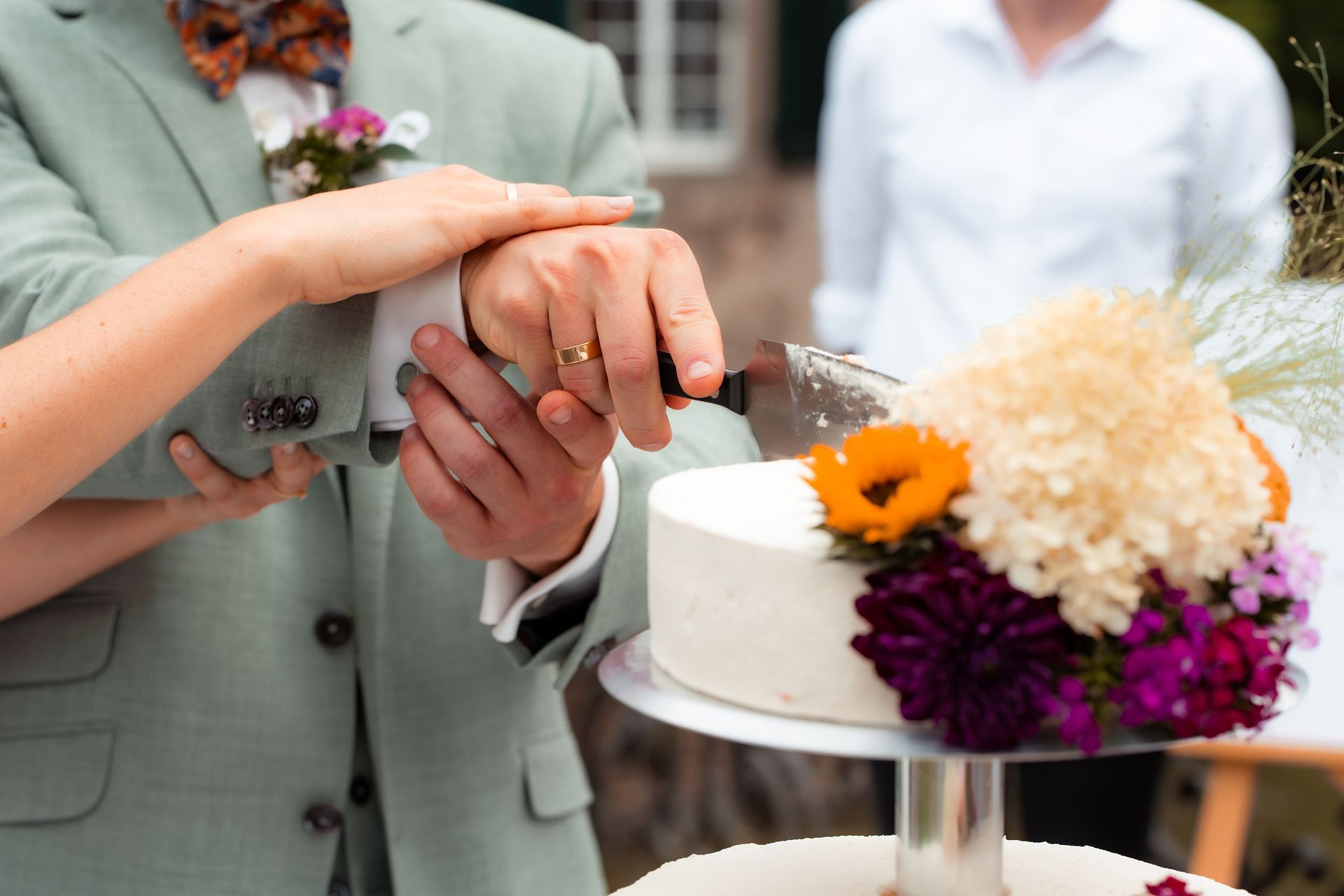 Braut und Bräutigam schneiden gemeinsam die Hochzeitstorte in Solingen an.