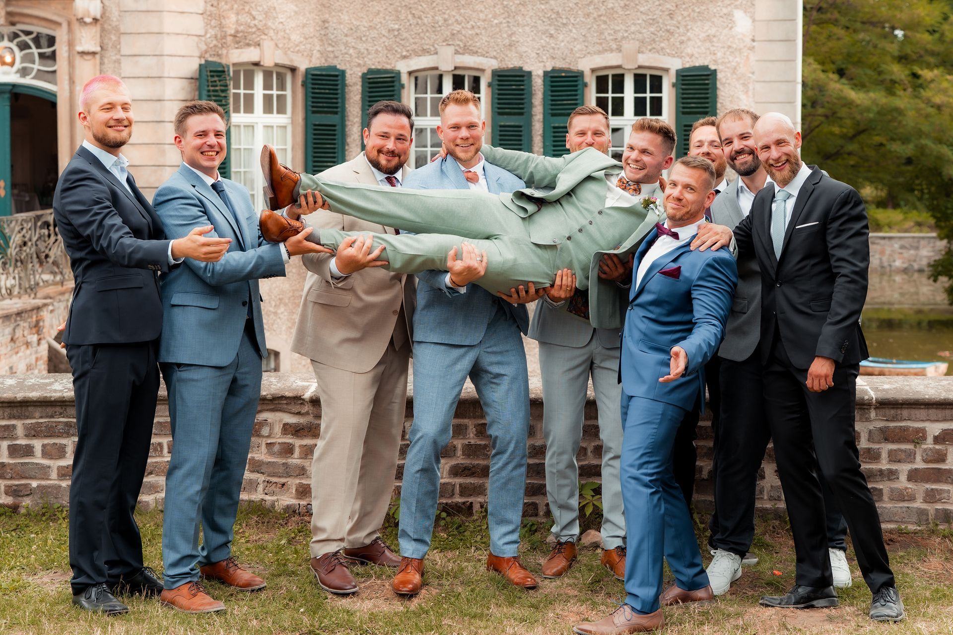 Gruppenfoto der Männer bei der Hochzeit in Solingen, die den Bräutigam hochheben.