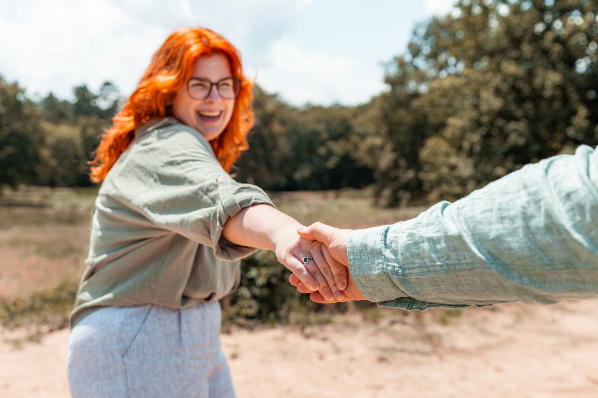 Braut lacht und hält die Hand ihres Partners beim Paarshooting in Troisdorf.