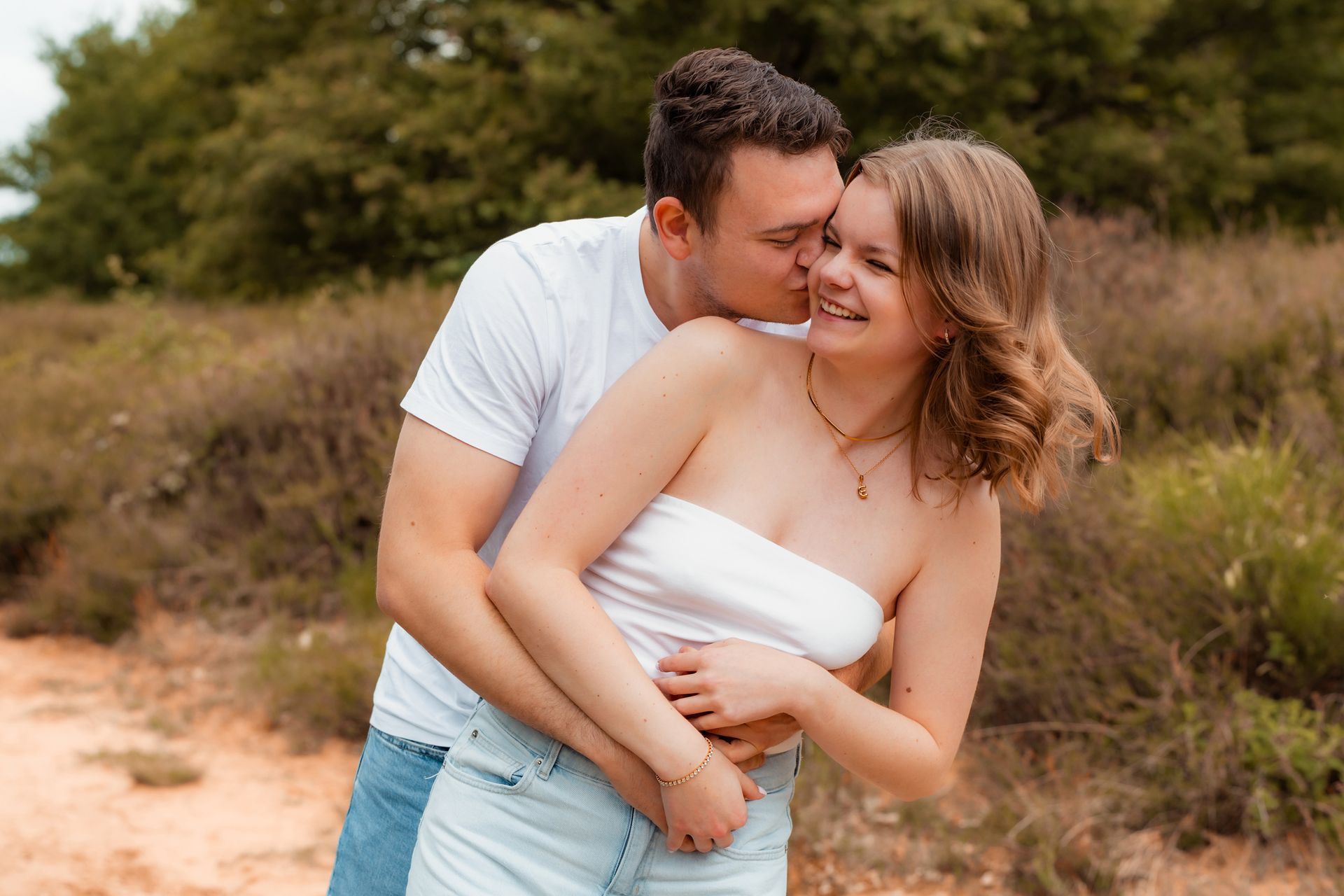Paar lacht eng umschlungen beim Fotoshooting in der Wahner Heide Troisdorf