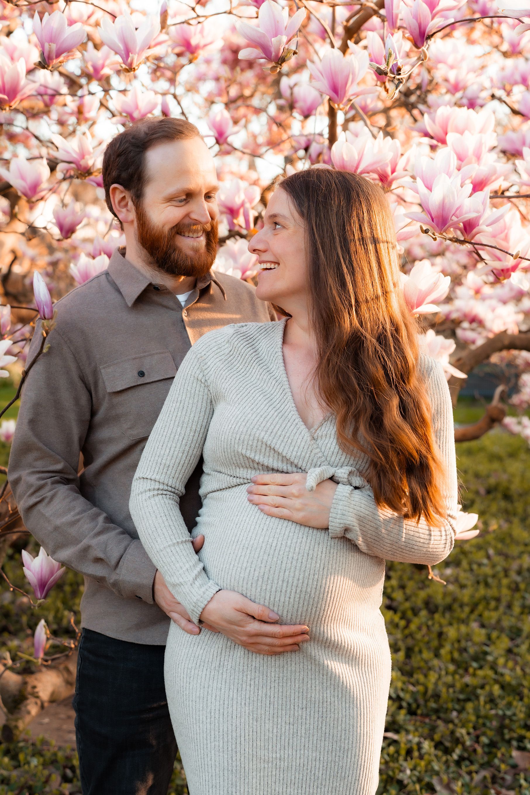 Babybauchshooting in Bremen – natürliche Babybauchfotos draußen mit liebevollen Umarmungen im Grünen.