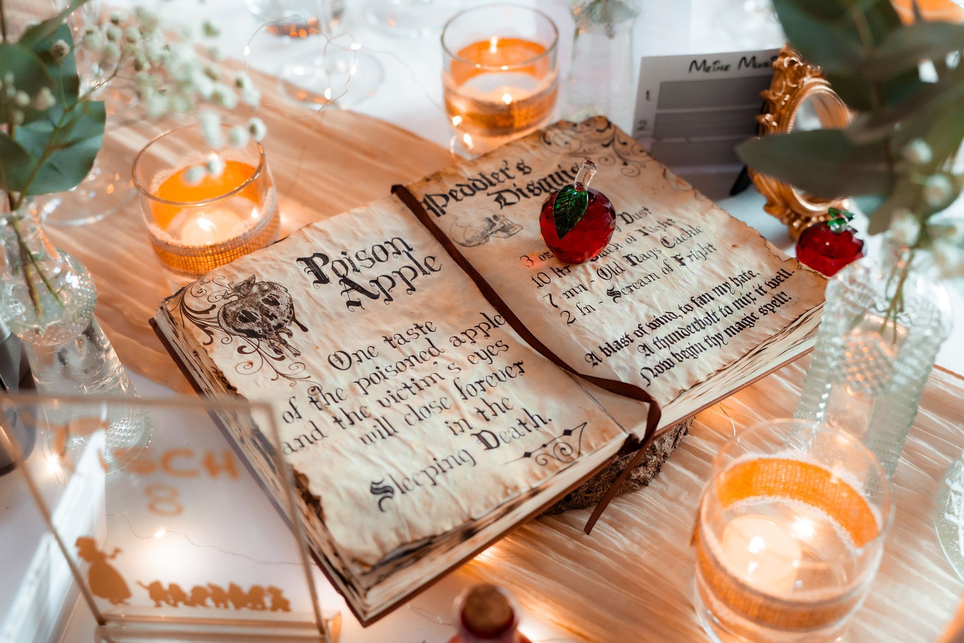 Disney-Tischdekoration im Festsaal des Grand Central Bremen mit goldenen Gläsern und Kerzen.