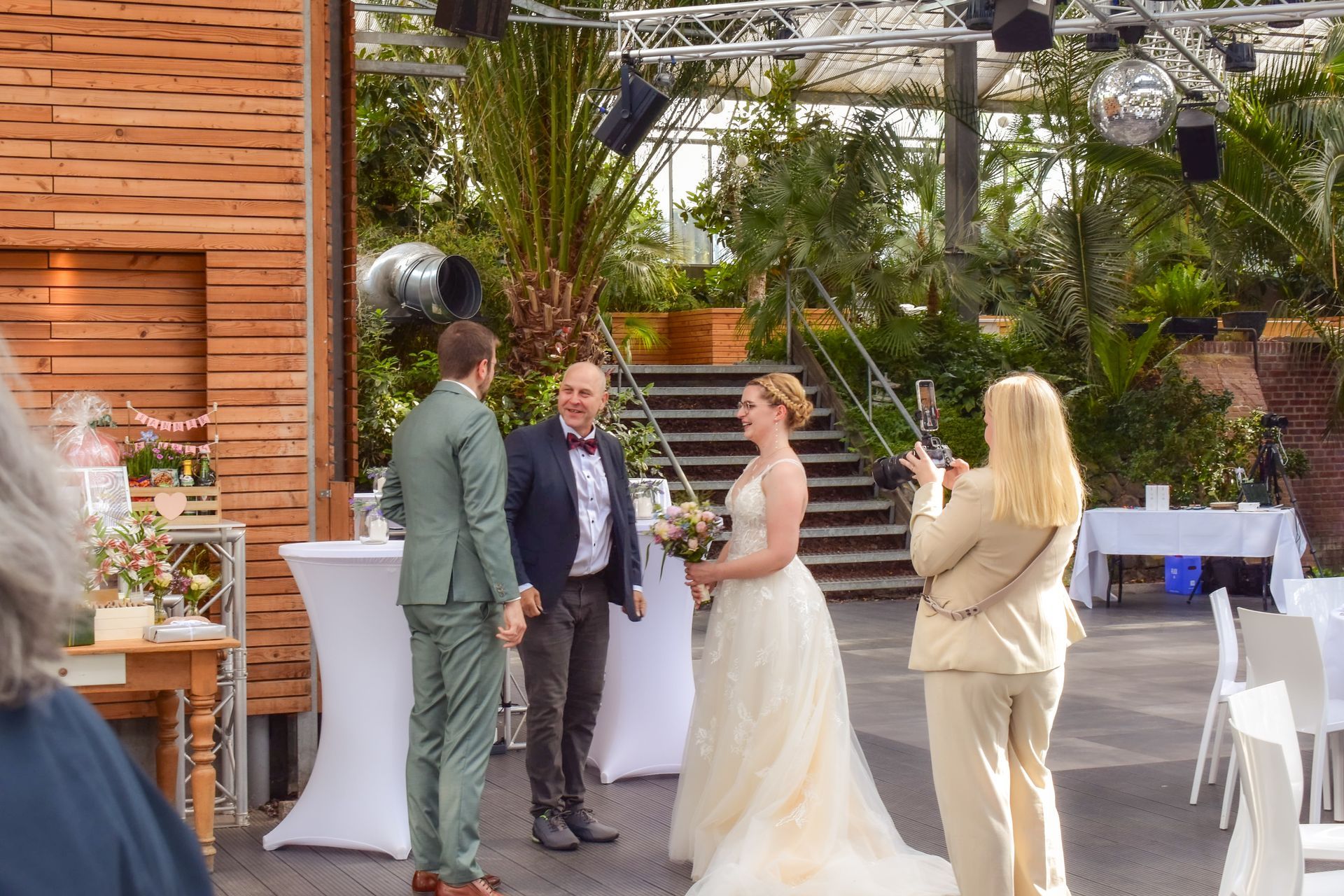 Fotografin Jenny Larrabe, während sie das Brautpaar im Gespräch mit ihrem DJ fotografiert.