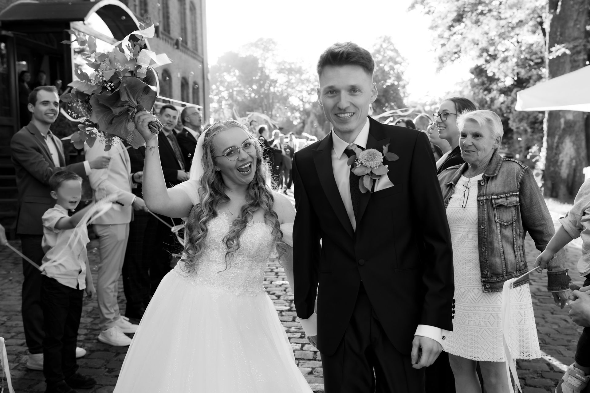Brautpaar wird jubelnd von Gästen nach der kirchlichen Trauung im Grand Central Bremen empfangen.
